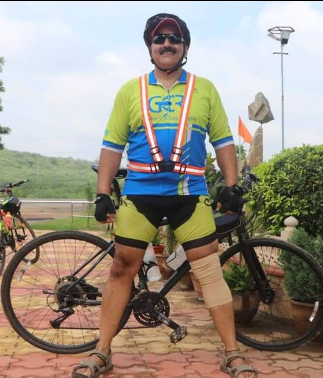 Subodh Tandon standing with his bicycle in cycling kit and a helmet.