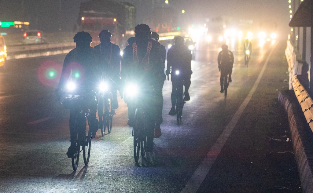 Cyclists riding at night on an Indian road during a brevet.