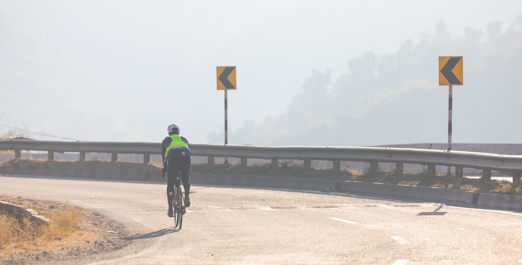 A cyclist riding around a bend during a brevet in India.